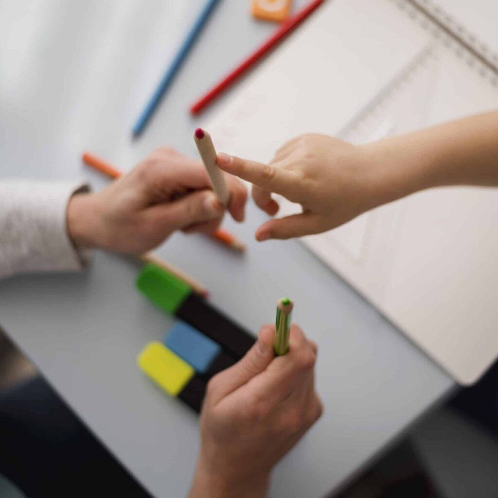 Een vinger wijst een kleurpotlood aan